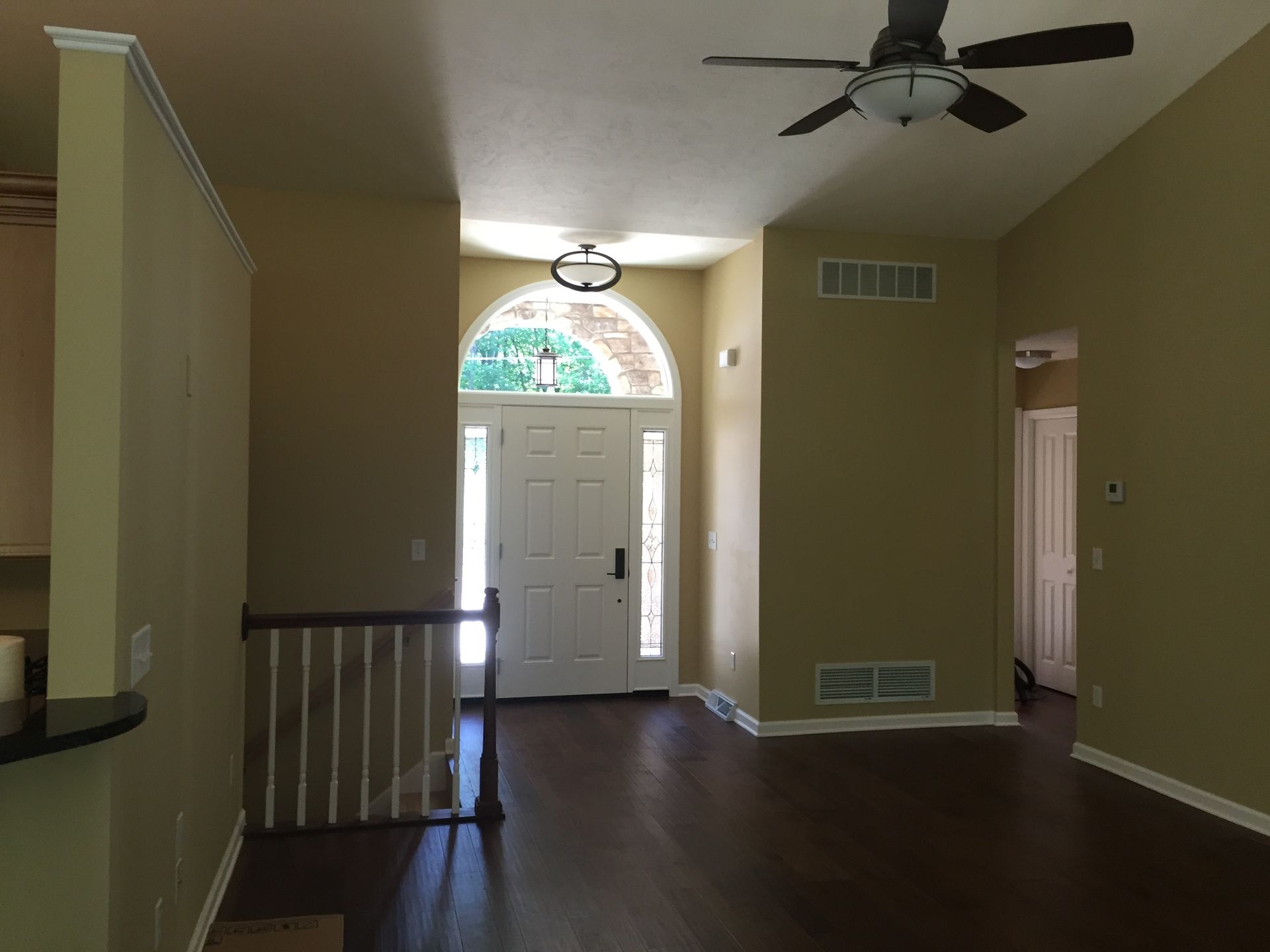 A hallway in a house with a ceiling fan