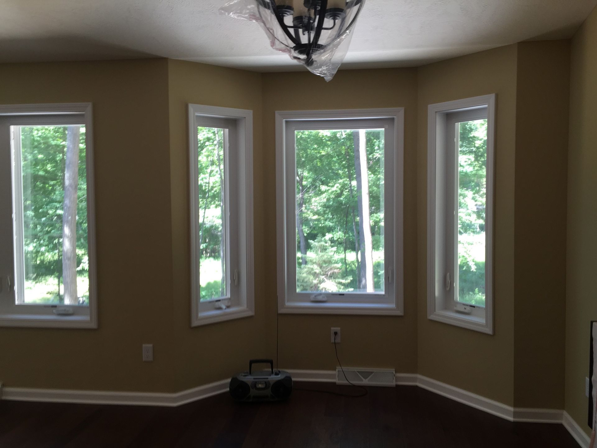 An empty room with three windows and a chandelier