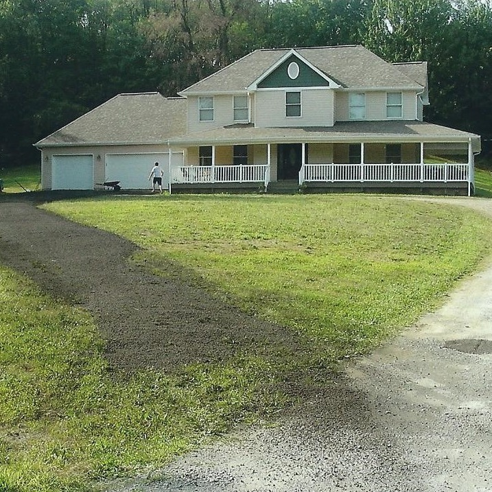 A white house with a green trim and a porch
