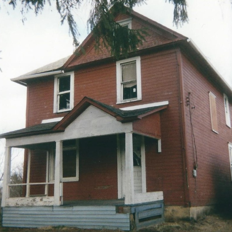 A large red brick house with a white porch