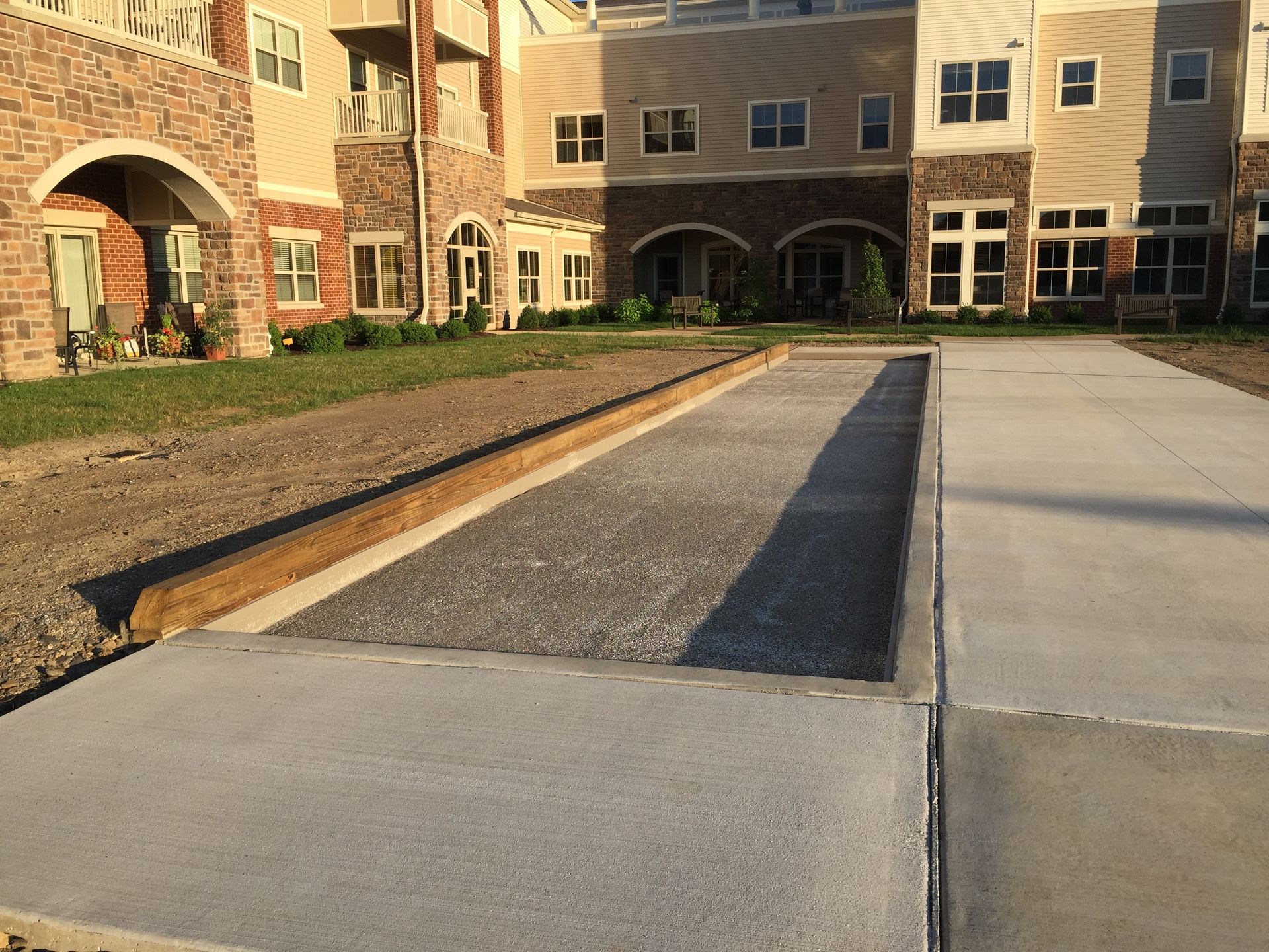 A concrete walkway in front of a large building