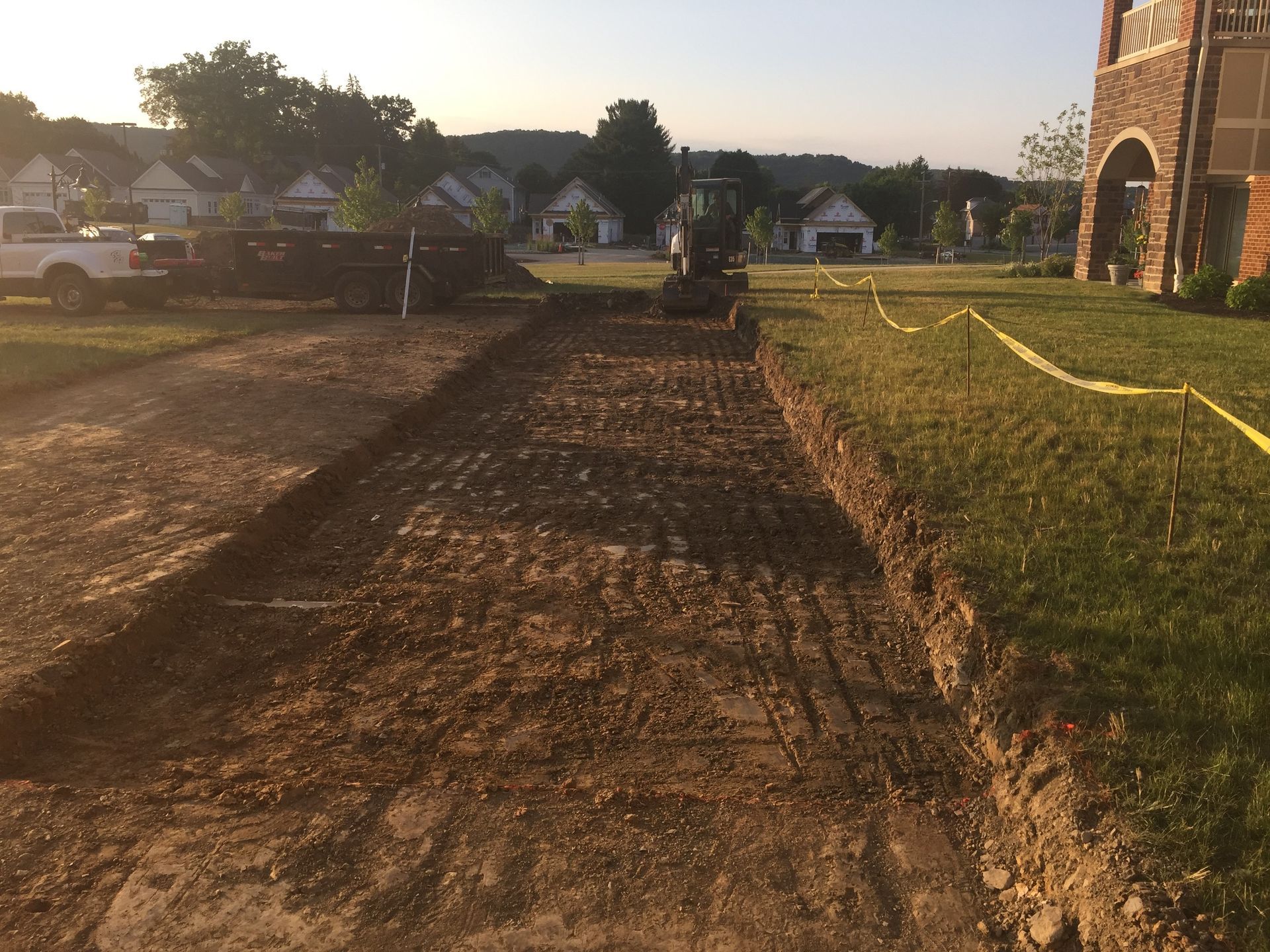 A dirt road is being built in front of a house