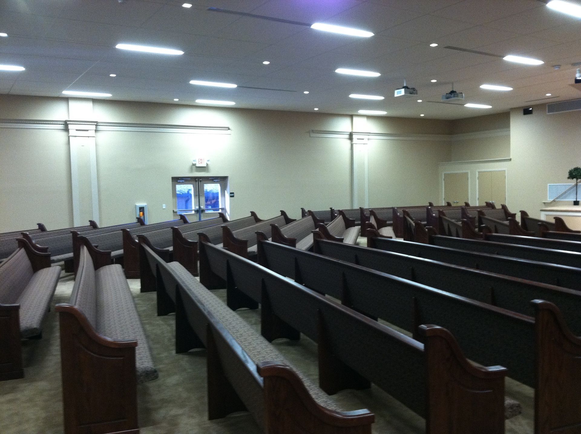 Rows of wooden benches in a large auditorium