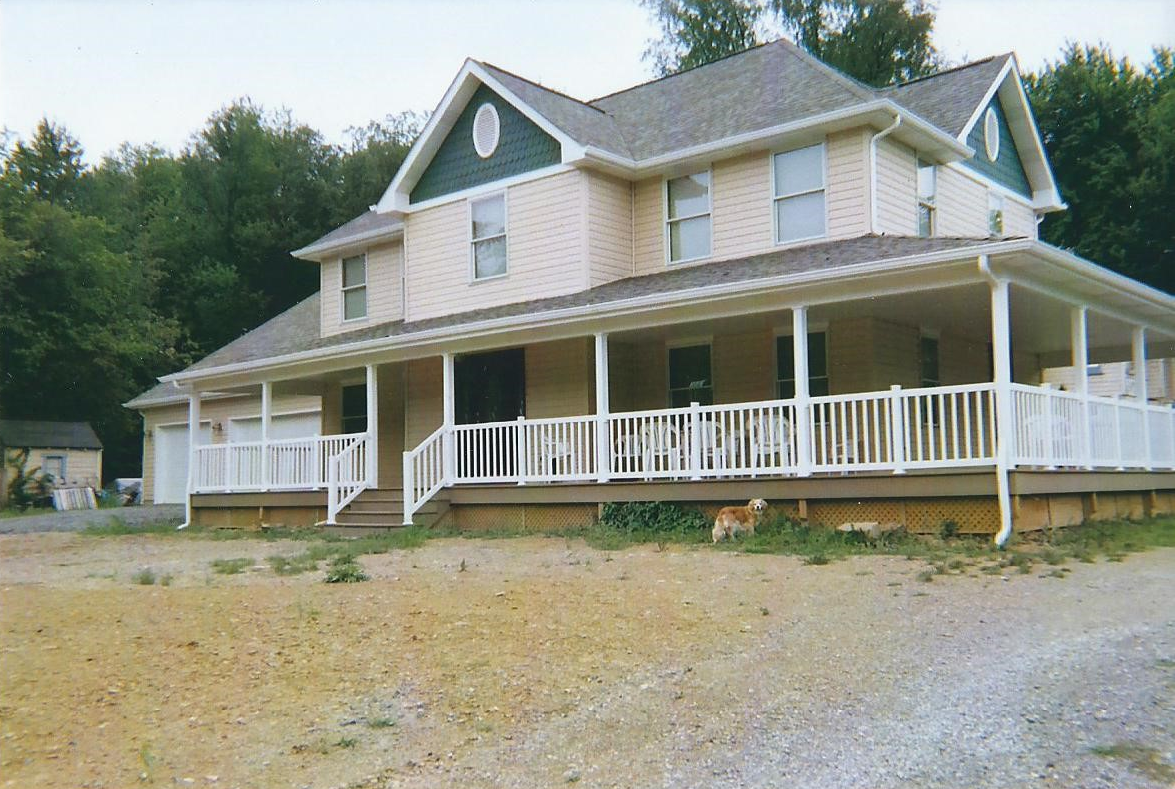 A large house with a large porch and white railing