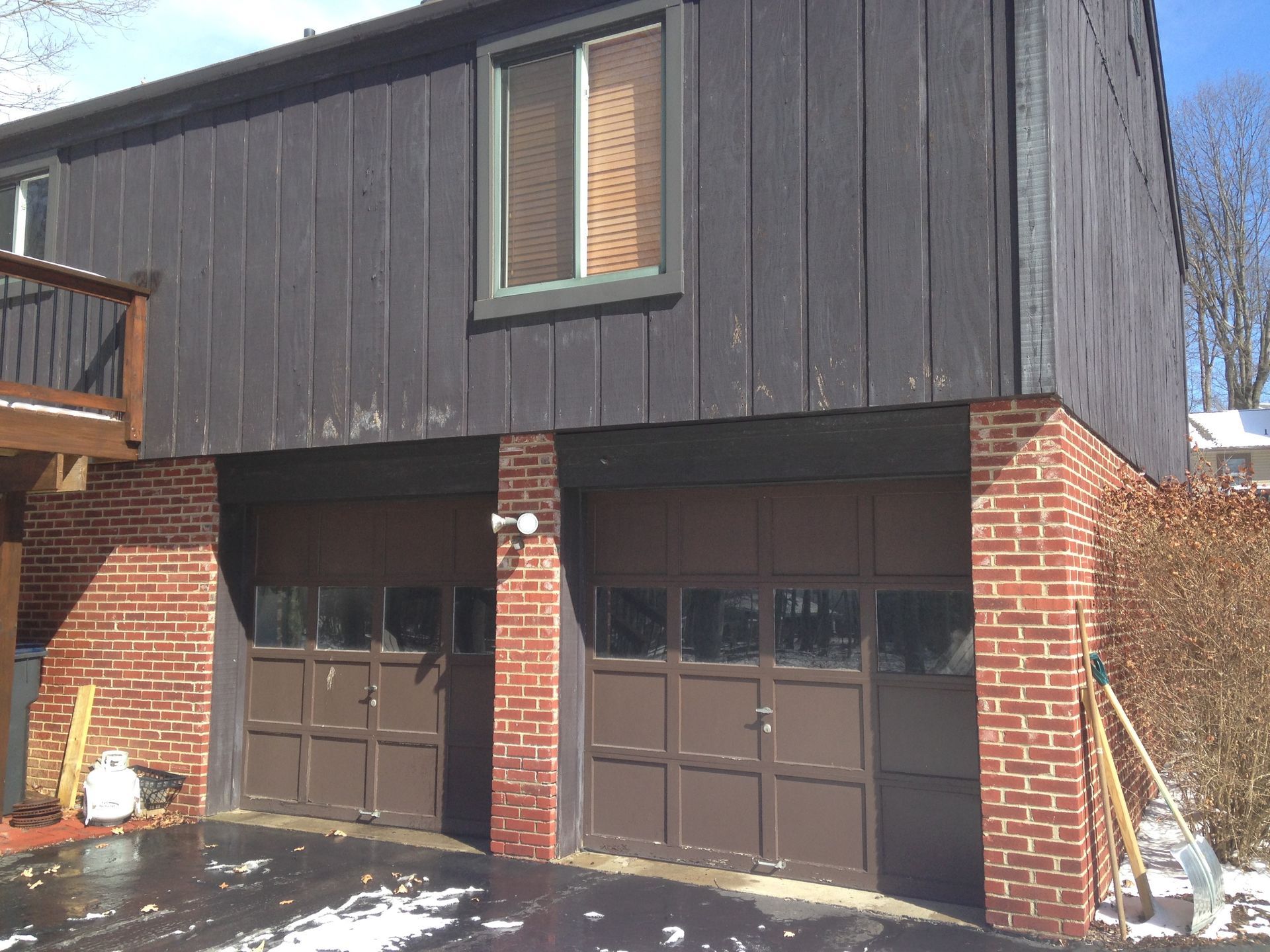 A house with two garage doors and a brick wall