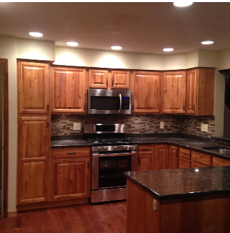 Wooden kitchen cabinets, stainless steel appliances, granite countertops, recessed lighting.
