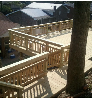 Wooden deck built around a tree, with multiple levels and railings.  A house is visible in the background.