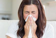 Woman blowing nose