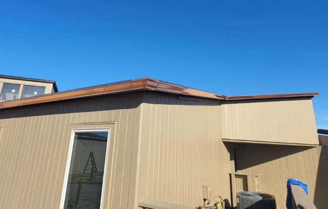 Beige building exterior with a brown roof, blue sky, and a glass door.