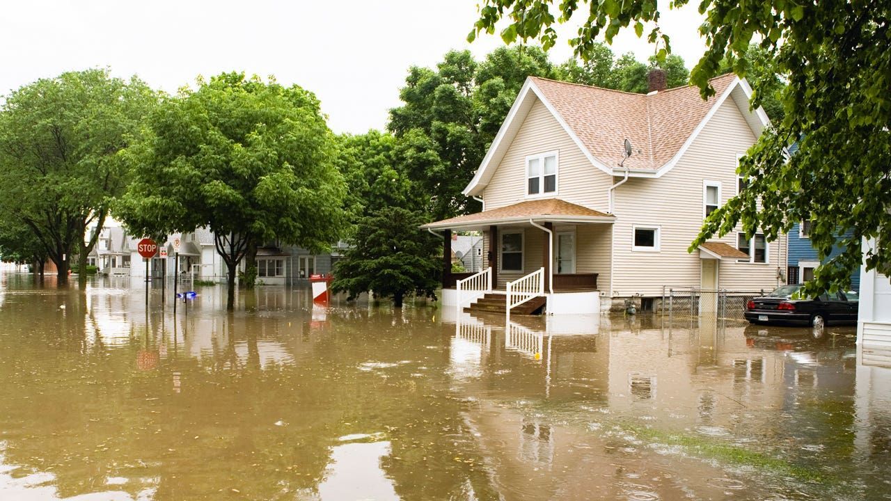 A flooded neighborhood with a house in the middle of it