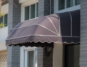 A gray awning over a door on a brick building