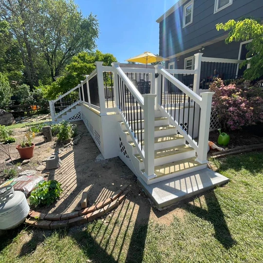 A white deck with stairs leading up to it