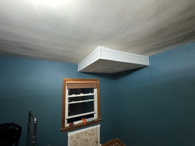 A room with a window and a box on the ceiling