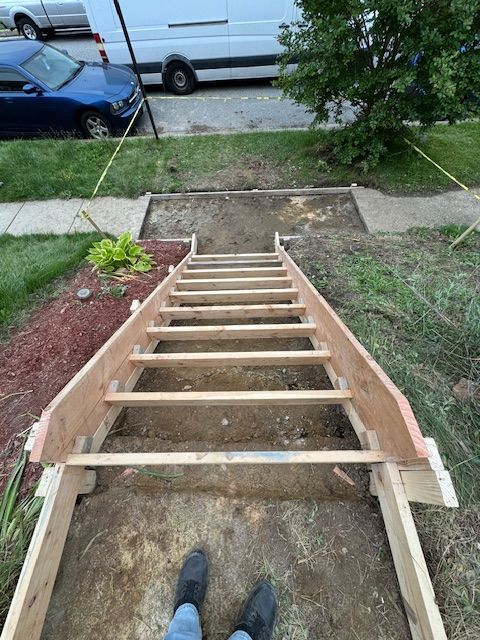 A person is standing on a wooden staircase that is being built.