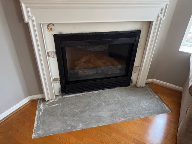 A fireplace in a living room with a rug on the floor.