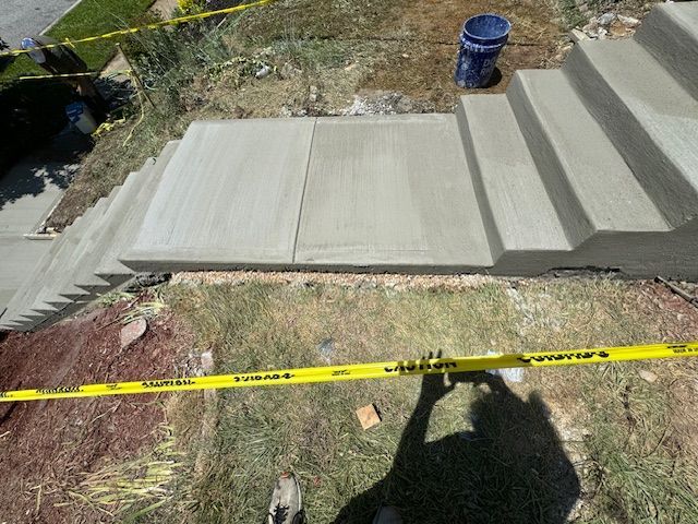 A concrete staircase is being built next to a yellow caution tape