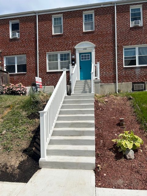 A brick building with stairs leading up to the front door