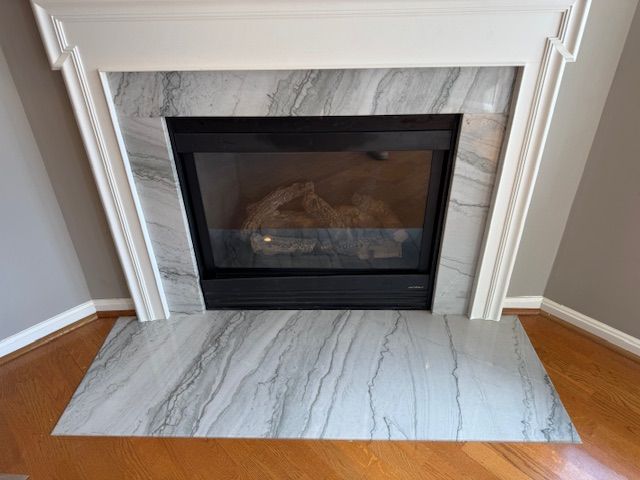 A fireplace with a marble mantle in a living room