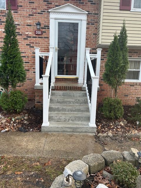 A brick house with a white porch and stairs