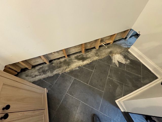 A room with a hole in the wall and a tile floor