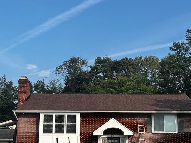 A brick house with a brown roof and a white door