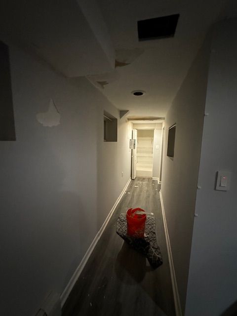 A long hallway with a red bucket on the floor