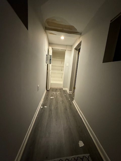 A dark hallway with a staircase in the background.