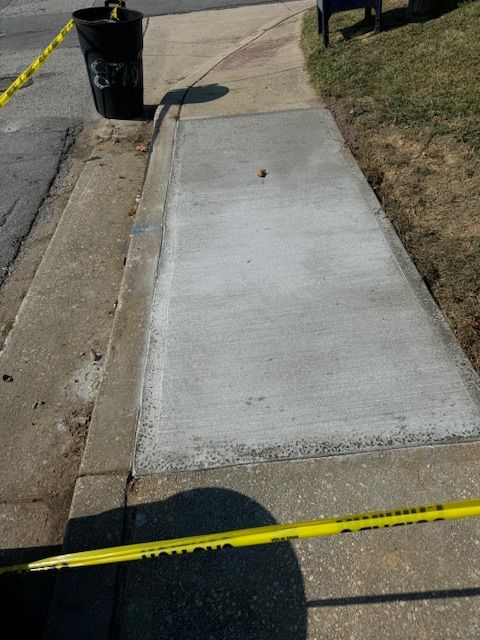 A concrete sidewalk with a yellow caution tape around it