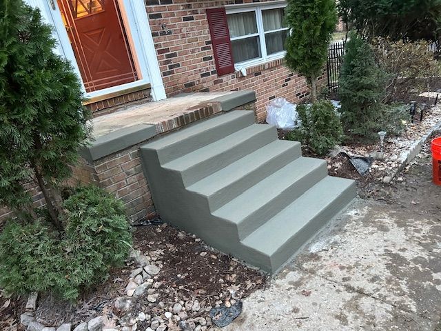 A set of concrete steps leading up to a brick house