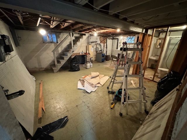 A basement with a ladder and stairs in it