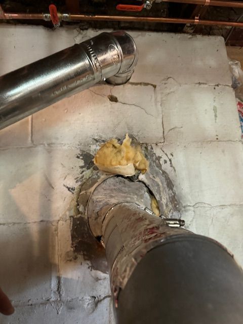 A close up of a pipe on a brick wall.