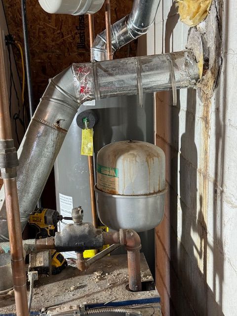 A water heater is sitting in a room next to a wall.