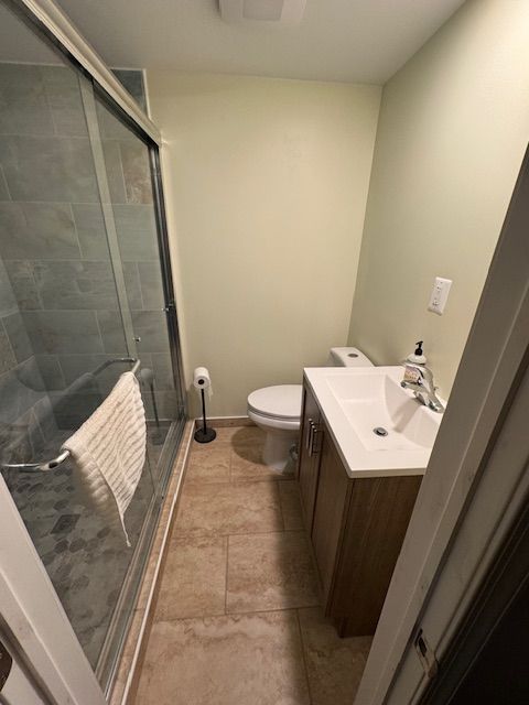 A bathroom with a toilet , sink , and shower.