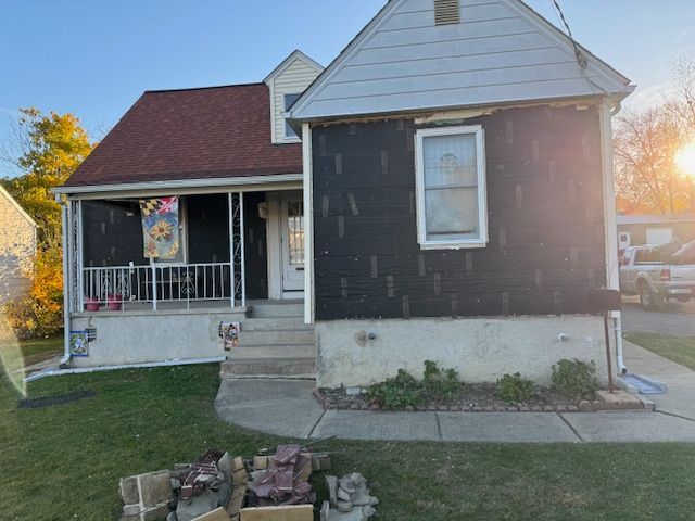 A small house with a porch and boxes in front of it