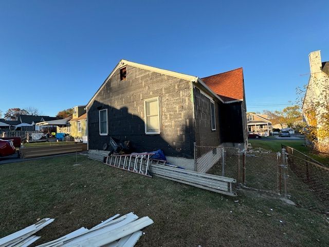 A house with a ladder in front of it is being remodeled.