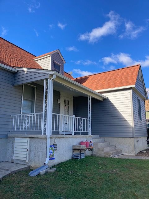 A house with a porch and a red roof
