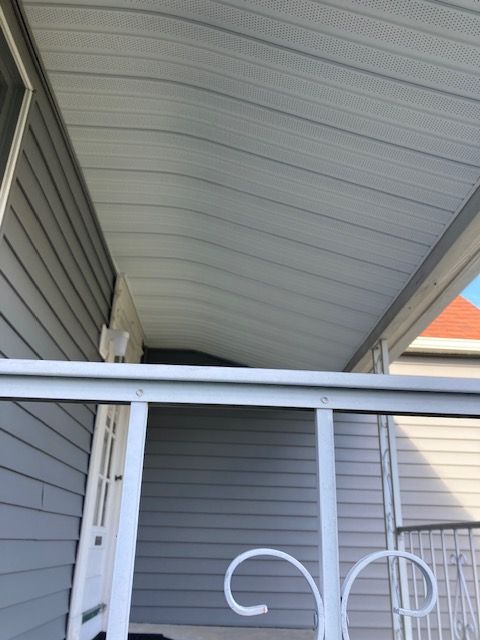 A porch with a white railing and a white ceiling