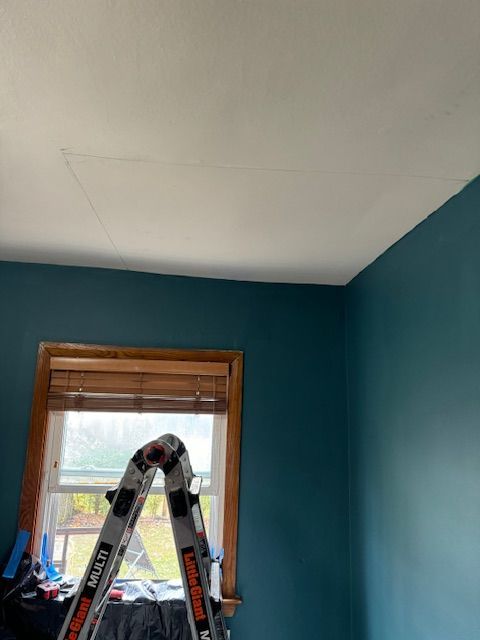 A ladder is sitting in a room next to a window