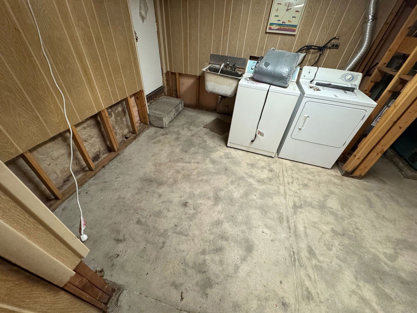 A laundry room with a washer and dryer and a sink