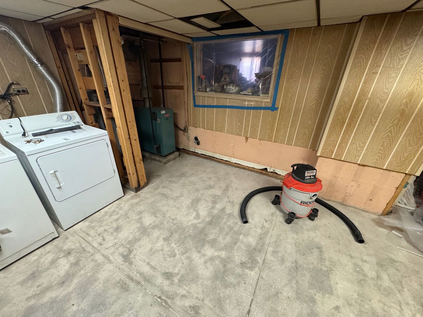 A laundry room with a washer and dryer and a vacuum cleaner