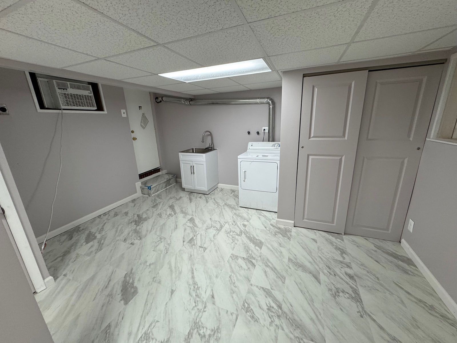 A newly restore laundry room with a washer and dryer in it