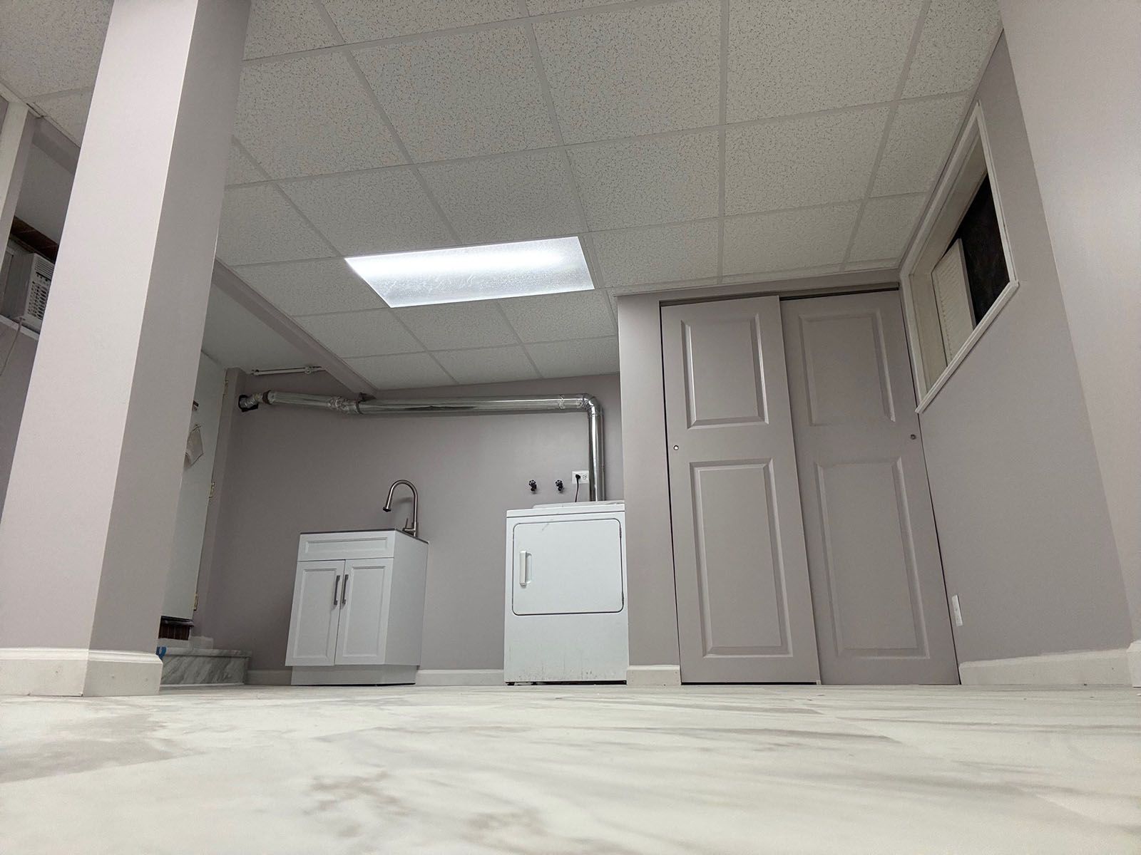 A newly restored laundry room with a washer and dryer and a sink