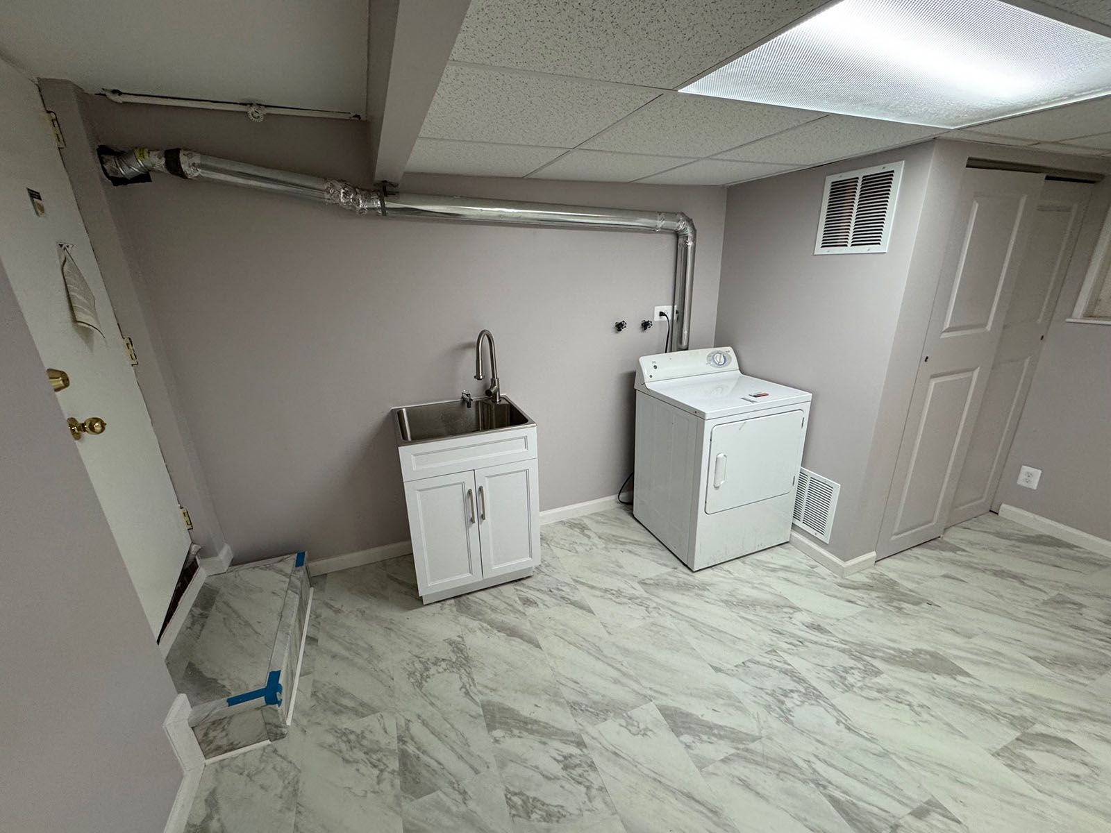A beautiful laundry room with a washer and dryer and a sink