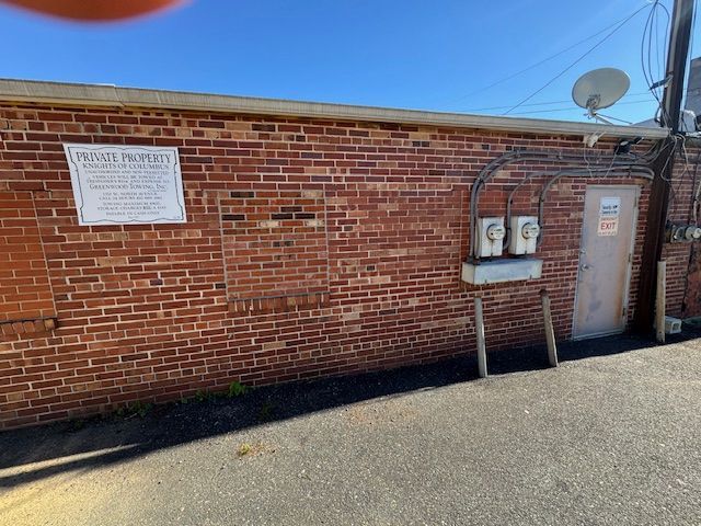 Red brick wall with a door, utility boxes, and a 