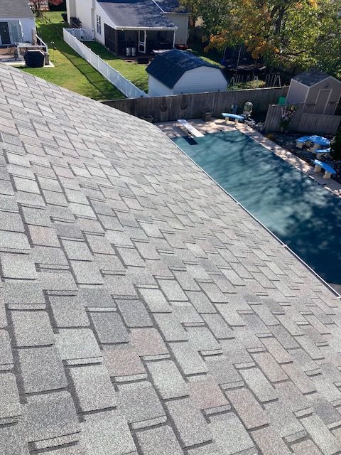 Shingled roof with a pool and backyard in view. Gray and beige shingles.