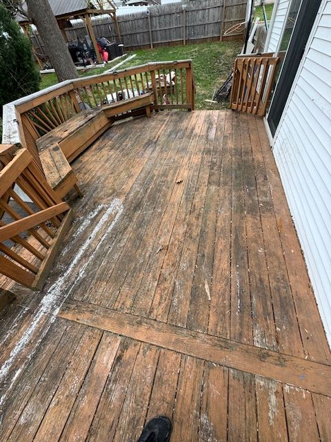 Wooden deck with weathered, peeling paint. Includes built-in bench, stairs, and railing. Exterior setting.