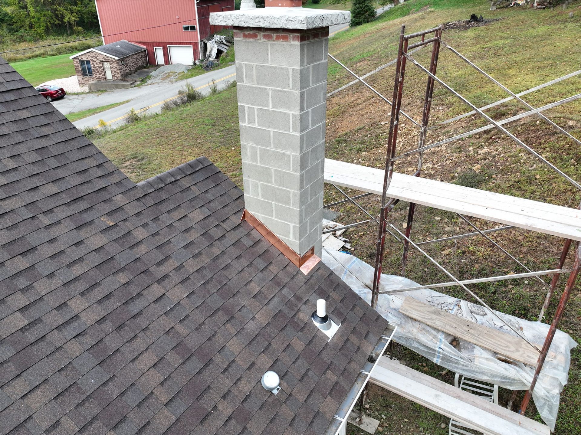 A chimney is being installed on the roof of a house.