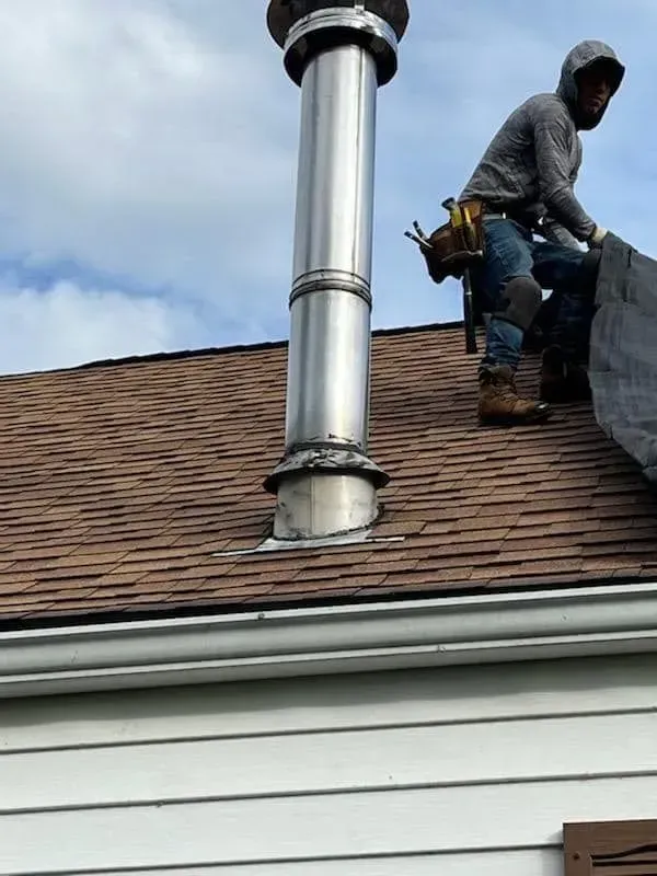 A man is working on the roof of a house.