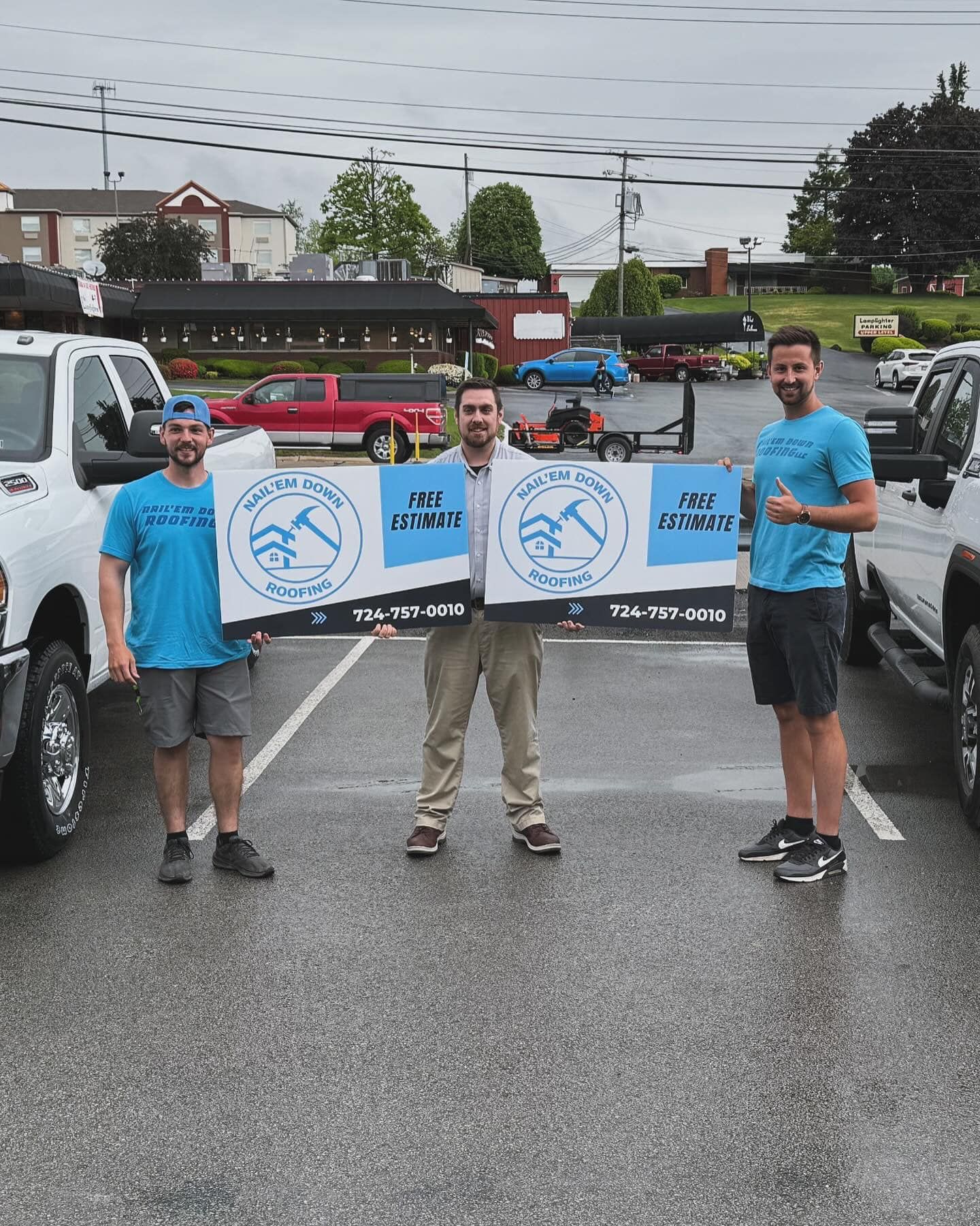 Three men are holding up signs in a parking lot