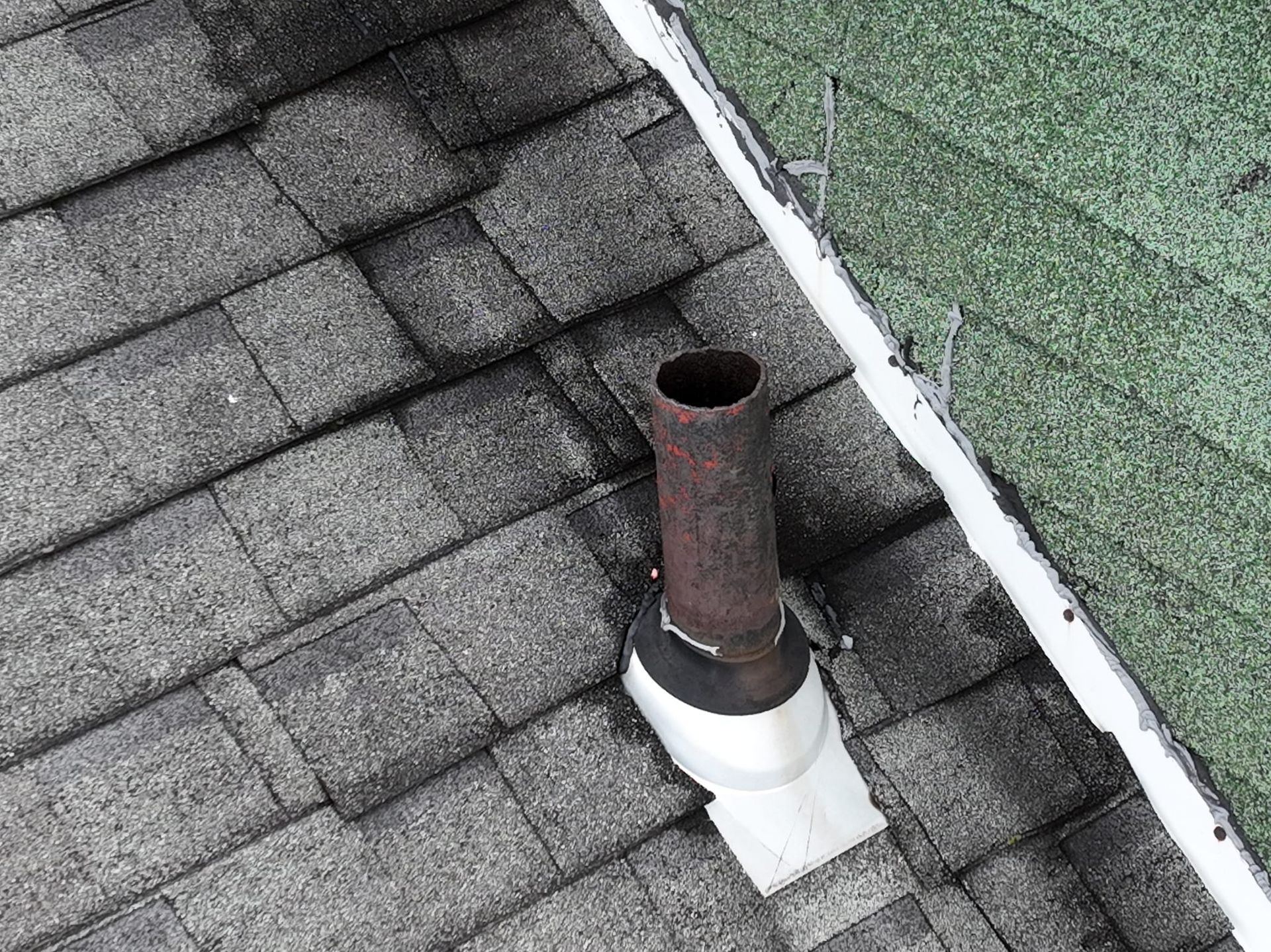 There is a chimney on the roof of a house.